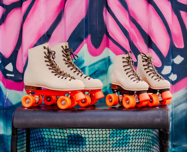 Kolme paria vintage-tyylisi&auml; rullaluistimia riviss&auml; v&auml;rikk&auml;&auml;n graffitisein&auml;n edess&auml;.