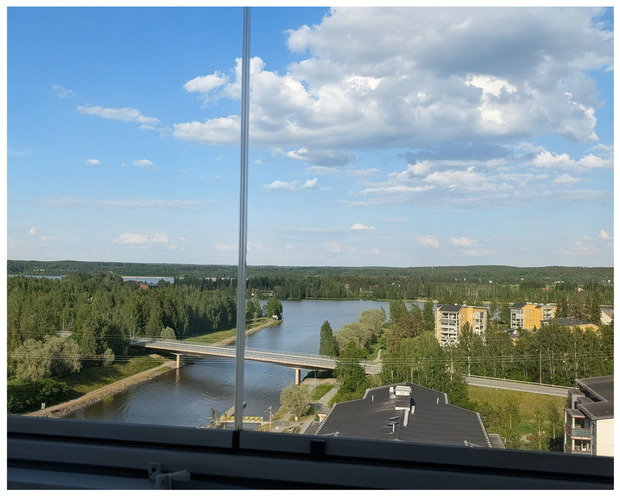 N&auml;kym&auml; asunnon parvekkeelta: j&auml;rvi, silta ja vehre&auml;t maisemat ymp&auml;rill&auml;.